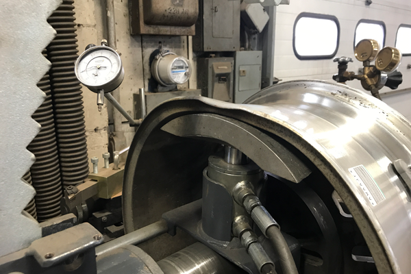 Tire rim being repaired on the rim straightening machine at Dias Spring Service in Erie, PA.